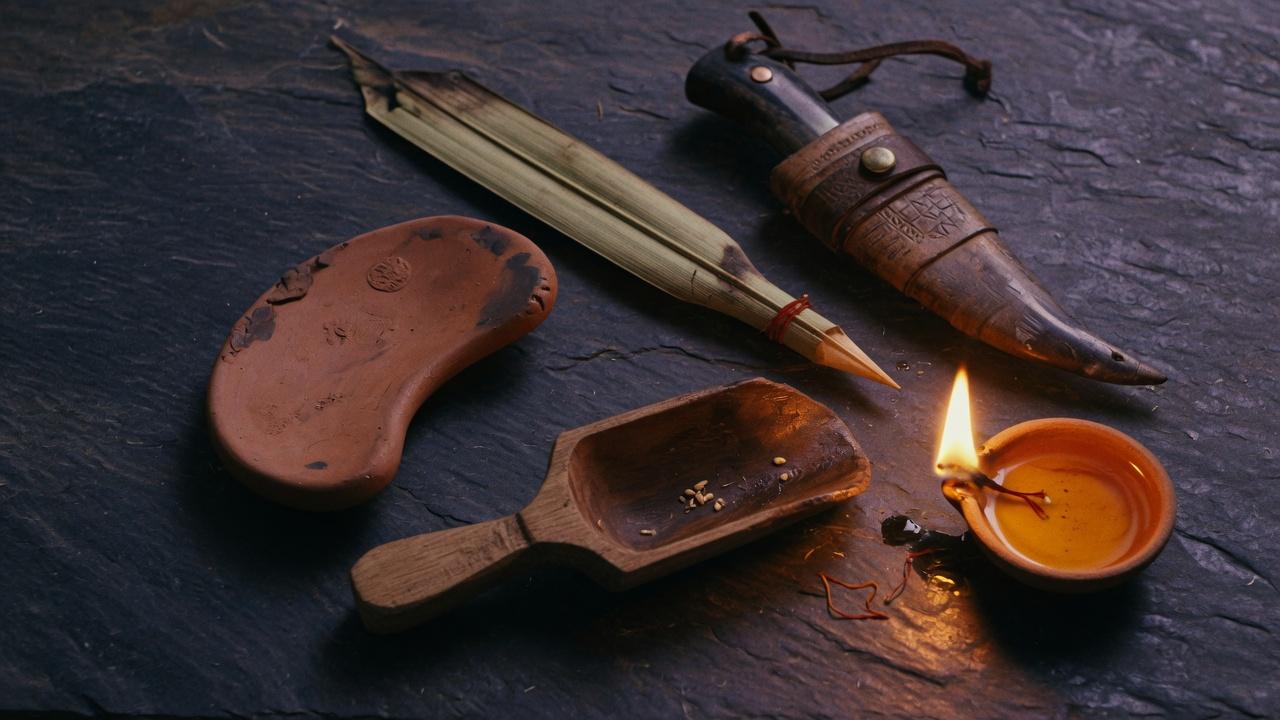 Four tools laid in a circle on dark stone